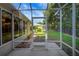 A view through the screen door of a screened porch to the grassy backyard at 2766 Privada Dr, The Villages, FL 32162