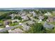 Expansive aerial view of a residential community showcasing well-maintained homes, lush landscaping, and nearby lake at 2821 Mediterranean Loop, Tavares, FL 32778