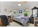 Comfortable bedroom featuring a queen bed, desk, chair, and ample natural light at 2821 Mediterranean Loop, Tavares, FL 32778