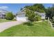 This home features a front lawn with driveway leading to the attached garage and mature landscaping at 2821 Mediterranean Loop, Tavares, FL 32778