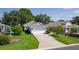 Well-maintained one-story home with a two-car garage, beautiful landscaping, and a paved driveway at 2821 Mediterranean Loop, Tavares, FL 32778
