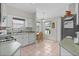 Efficient kitchen with tile flooring, white cabinets, ample counter space, and natural light at 2821 Mediterranean Loop, Tavares, FL 32778