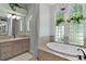 Bright bathroom showcasing a soaking tub, vanity, and natural light from the beautiful windows at 2904 Avalos Dr, The Villages, FL 32162