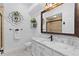 Bright bathroom showcasing a granite countertop, decorative mirror, and tiled shower at 2904 Avalos Dr, The Villages, FL 32162