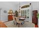 Dining room featuring hardwood floors, a unique light fixture, and large windows with shutter-style blinds at 2904 Avalos Dr, The Villages, FL 32162