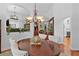 Formal dining room with hardwood floors, elegant chandelier, and open view into the living area at 2904 Avalos Dr, The Villages, FL 32162