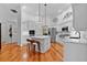 Modern white kitchen with a center island, stainless steel appliances, and hardwood flooring at 2904 Avalos Dr, The Villages, FL 32162