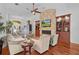 Spacious living room featuring a stone fireplace, hardwood floors, and a ceiling fan at 2904 Avalos Dr, The Villages, FL 32162