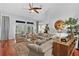 Bright living room featuring high ceilings, a ceiling fan, hardwood floors, and access to the lanai at 2904 Avalos Dr, The Villages, FL 32162