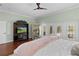 Bright main bedroom with french doors, media center, a sauna, wood floors and a ceiling fan at 2904 Avalos Dr, The Villages, FL 32162