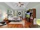 Relaxing main bedroom with a tray ceiling, wood floors, and large entertainment center at 2904 Avalos Dr, The Villages, FL 32162