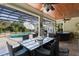 Covered patio dining area with a glass table, wicker chairs, and views of the pool and screen enclosure at 2904 Avalos Dr, The Villages, FL 32162