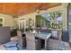 Covered patio dining area featuring a glass table, wicker chairs, an outdoor kitchen, and a grill at 2904 Avalos Dr, The Villages, FL 32162