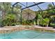 Stunning pool and spa featuring stone accents and tropical landscape at 2904 Avalos Dr, The Villages, FL 32162