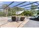 Screened-in pool area with lounge chairs and lush tropical landscaping at 2904 Avalos Dr, The Villages, FL 32162