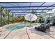 Screened-in pool area with lounge chairs and umbrellas, perfect for relaxing and enjoying the outdoors at 2904 Avalos Dr, The Villages, FL 32162