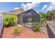 Screened-in patio overlooks a landscaped yard with mature trees and rock features at 2967 Thayer Ter, The Villages, FL 32163