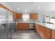 Modern kitchen featuring stainless steel appliances and an eat-in counter with wood cabinets at 2967 Thayer Ter, The Villages, FL 32163