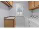 Functional laundry room with a utility sink, ample storage, and a modern washer and dryer at 2967 Thayer Ter, The Villages, FL 32163