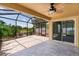 Relaxing screened patio with brick flooring, ceiling fan, and stunning lake views at 2967 Thayer Ter, The Villages, FL 32163