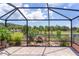 Screened-in porch overlooking a serene pond with a charming waterfall feature at 2967 Thayer Ter, The Villages, FL 32163