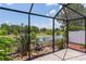 View from the screened lanai, featuring a tranquil lake view and lush greenery at 2967 Thayer Ter, The Villages, FL 32163