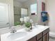 Bright bathroom featuring a double vanity, white countertops, a shower, and nice decor at 3181 Hill Point St, Minneola, FL 34715