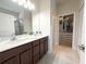 Bathroom features double vanity, brown cabinets, and an adjacent walk-in closet at 3181 Hill Point St, Minneola, FL 34715