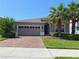 Charming single-Gathering home featuring a brick driveway, two-car garage, and lush landscaping at 3181 Hill Point St, Minneola, FL 34715