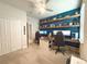 Spacious home office featuring a built-in desk, shelving, and comfortable seating at 3181 Hill Point St, Minneola, FL 34715