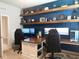 Spacious home office featuring a built-in desk, shelving, and comfortable seating at 3181 Hill Point St, Minneola, FL 34715