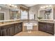 Luxurious bathroom featuring dual vanities, a soaking tub, granite countertops, and decorative mirrors at 3222 San Leo Dr, Orlando, FL 32820