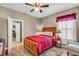 Bedroom featuring a wooden bed frame, wood laminate flooring, and natural light from the window at 3222 San Leo Dr, Orlando, FL 32820