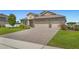 Charming single-Gathering home with a well-manicured lawn and a paver driveway leading to a two-car garage at 3222 San Leo Dr, Orlando, FL 32820