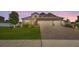 Charming single-Gathering home showcasing a well-manicured lawn and brick driveway at sunset at 3222 San Leo Dr, Orlando, FL 32820
