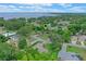 Aerial view of the property in a lush, green neighborhood with a lake visible in the distance at 33 Palm Dr, Yalaha, FL 34797