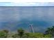 Expansive aerial view of pier extending into a vast body of water with lush green trees surrounding the shoreline at 33 Palm Dr, Yalaha, FL 34797