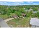 Lovely home with well-manicured lawn, mature trees, and screened in porch, as seen from above at 33 Palm Dr, Yalaha, FL 34797