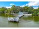 Aerial view of dock extending into the lake with a small building on the end, perfect for lakeside living at 33 Palm Dr, Yalaha, FL 34797