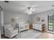 Bright and airy Bedroom featuring a crib, rocking chair, and natural light from a large window at 33 Palm Dr, Yalaha, FL 34797