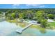 Scenic waterfront community dock with pier extending into a tranquil lake surrounded by lush greenery at 33 Palm Dr, Yalaha, FL 34797