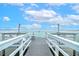 Picturesque dock with white railings and chairs offers stunning views of the tranquil water at 33 Palm Dr, Yalaha, FL 34797