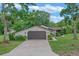 Charming single-story home featuring a two-car garage, well-maintained lawn, and beautiful landscaping at 33 Palm Dr, Yalaha, FL 34797