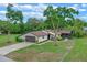 Beautifully landscaped home with a two-car garage, manicured lawn, and a cozy screened-in porch at 33 Palm Dr, Yalaha, FL 34797