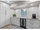 Stylish kitchen with white cabinets, stainless steel appliances, beverage fridge, and ample counter space at 33 Palm Dr, Yalaha, FL 34797