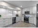 Modern kitchen featuring white cabinets, stainless steel appliances, and bright natural light at 33 Palm Dr, Yalaha, FL 34797