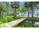 Scenic wooden bridge crossing a tranquil stream with lush greenery and view of the lake at 33 Palm Dr, Yalaha, FL 34797