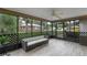 Relaxing screened patio with comfortable seating and wood-look tile flooring, perfect for outdoor enjoyment at 33 Palm Dr, Yalaha, FL 34797