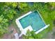 Aerial view of a refreshing pool surrounded by lush greenery and mature trees in a tropical setting at 33 Palm Dr, Yalaha, FL 34797