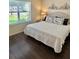Cozy bedroom featuring a large bed, window with blinds, and dark hardwood flooring at 3337 Candlebrook St, The Villages, FL 32162